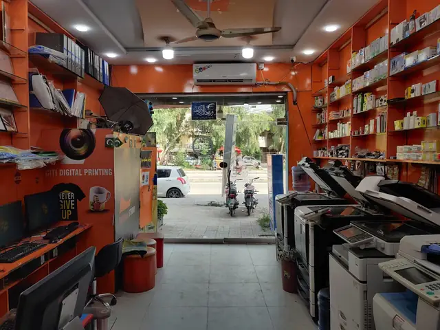Inside the shop: photocopiers, the design desk and orange shelves of stationery